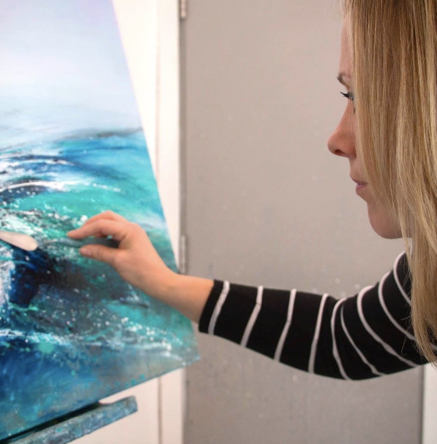 Close-up photograph of Tessa Houghton painting sea waves